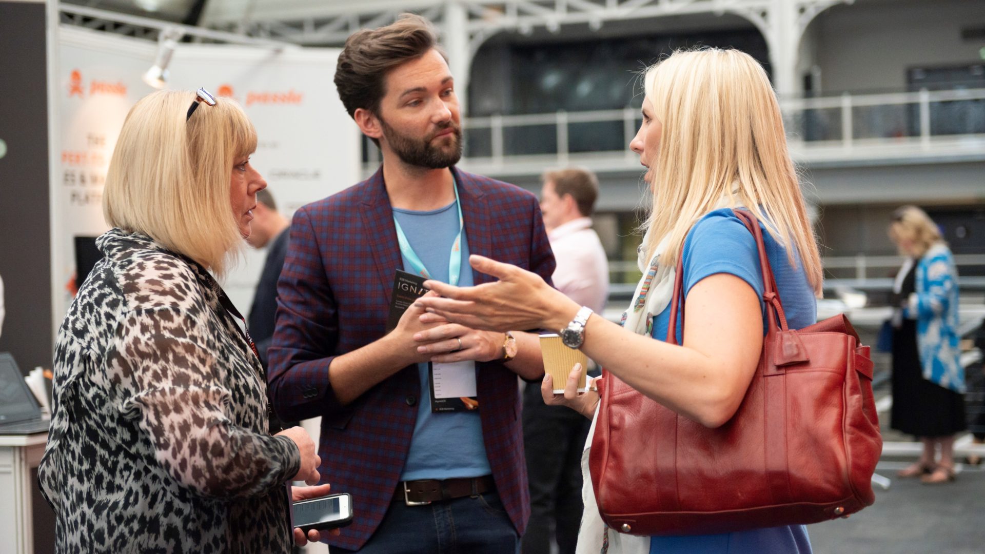 Three people conversing at a marketing event.