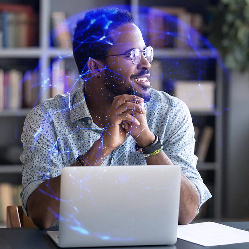 A man in front of a laptop visualizing a technology in the shape of a spherical network